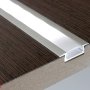 Silver anodized MICRO-NK low profile recessed aluminum channel installed in laminate flooring with optional frosted lens