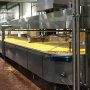 Multiple NSF-compliant 150W UFO high bay washdown light fixtures illuminating a cheese factory