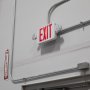 MaxLite Combination Emergency Exit Light installed over a warehouse door